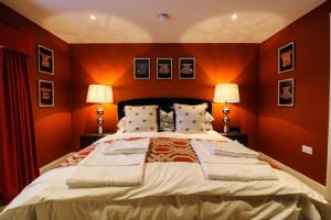 霍顿利斯普林Three Horseshoes Leamside的一间卧室配有一张带橙色墙壁的大床