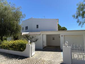 维拉摩拉Vivenda Júlia e Tavares的白色的房子,设有大门和车库