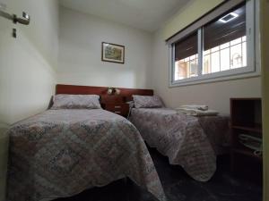 圣胡安Nuestro Crepúsculo的一间卧室设有两张床和窗户。