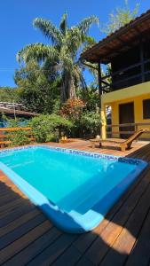 阿布拉奥Canoa Abraão的棕榈树木甲板上的蓝色游泳池