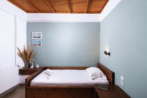 卡米拉日OVGORA - Aretousa sea view room, Kamilari village的一间卧室配有白色床单和木制天花板。