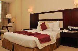 亚的斯亚贝巴和谐酒店的配有一张大床和一部电话的酒店客房