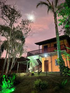 圣安娜-杜斯蒙蒂斯Pousada Chalés dos Montes的棕榈树的夜屋
