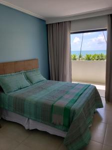 伊塔齐米林Itacimirim - Duplex Aconchegante, Pé na Areia的一间卧室设有一张床,享有海景