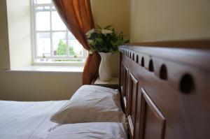 罗斯康芒Jacksons Restaurant and Accommodation的一间卧室配有一张床和一个植物窗户