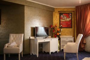 布拉迪斯拉发克托娃汽车旅馆的配有电视、两张椅子和一张书桌的房间