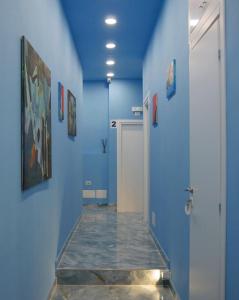 那不勒斯Attico Central Station Napoli的走廊设有蓝色的墙壁和瓷砖地板