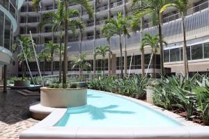 德班2 Sleeper SEA VIEWS Apartment -- Near MSC Cruise Terminal的棕榈树建筑前的游泳池