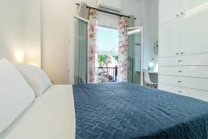 AnemómylosWhite nest in Corfu town的白色的卧室设有一张大床和一个窗户