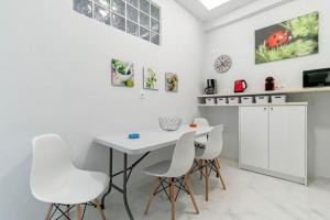 AnemómylosWhite nest in Corfu town的白色的厨房配有白色的桌子和白色的椅子