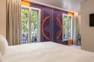 巴黎Graphik Montparnasse的卧室设有白色大床和窗户。