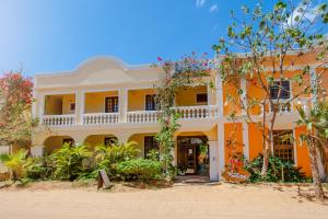 杰里科科拉Hotel Villa Beija Flor的一座种植了树木和植物的橙色和白色建筑