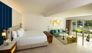 蓬塔卡纳Hard Rock Hotel & Casino Punta Cana - All Inclusive的一间卧室配有一张床,客厅配有沙发