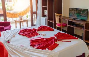 杰里科科拉Hotel Villa Beija Flor的上面有红色弓的床铺