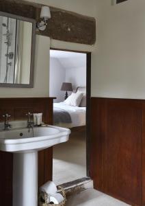 拉科克天使神迹宾馆的一间带水槽、床和镜子的浴室