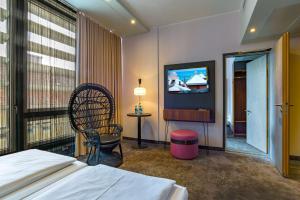 慕尼黑elaya hotel munich city的一间酒店客房,配有一张床和一台电视