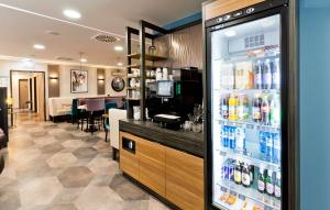 慕尼黑elaya hotel munich city的一间储藏室,里面装满了饮料的冰箱