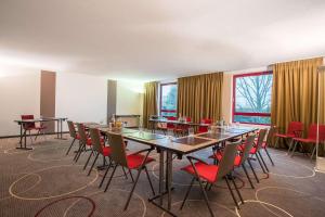上乌瑟尔elaya hotel frankfurt oberursel的一间会议室,配有长桌子和椅子