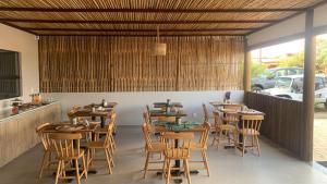 费尔南多 - 迪诺罗尼亚Pousada Sela Gineta的用餐室配有木桌和椅子