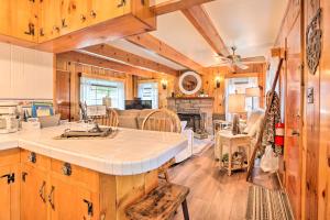 赖特伍德Wrightwood Cabin with Cozy Interior!的一间厨房和一间带木墙及桌子的客厅