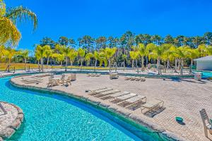 奥兰治比奇The Wharf 805的一个带躺椅的度假村游泳池,并种植了棕榈树