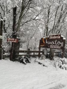 普埃洛湖Huala Hosteria的围栏旁的雪地里有两个标志