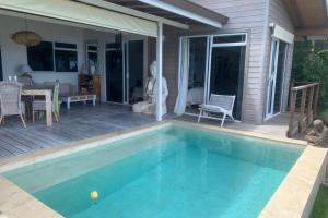 普纳奥亚Villa WABISABI cosy home的一座带游泳池和庭院的房子