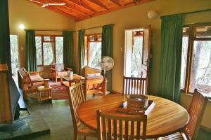 Simunye哈雷恩皇家国家公园山林小屋的客厅配有木桌和椅子