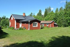 奥萨Orsastuguthyrning-Oljonsbyn的院子里有黑色屋顶的红色房子