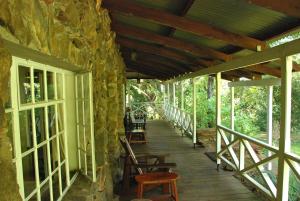 Lobamba赖利岩石山顶山林小屋的一个带椅子和石墙的木门廊