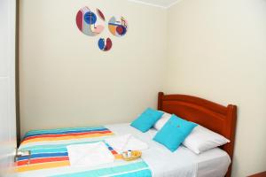 伊察Apartamento Hermoso en Residencial - Huacachina的一张带色彩缤纷枕头的床,墙上有心