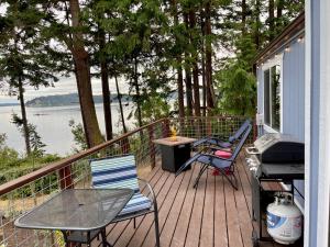 Port LudlowPrivate Beach - Port Ludlow Beach Cottage on Puget Sound的一个带桌椅和烧烤架的甲板