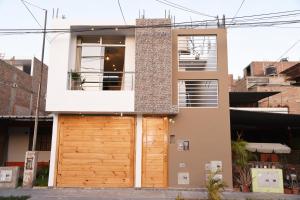 伊察Apartamento Hermoso en Residencial - Huacachina的一座带木制车库门的房子