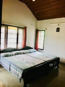 马迪凯里La Paz Coorg homestay at Madikeri town的一间带一张大床的卧室,位于带窗户的房间内