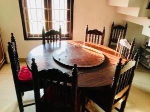 马迪凯里La Paz Coorg homestay at Madikeri town的木制餐桌、椅子和大木桌