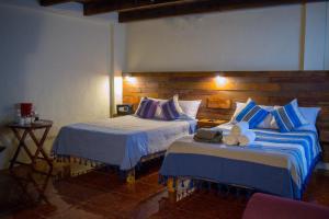 圣克里斯托瓦尔-德拉斯卡萨斯Arte Sano Hotel San Cristobal的酒店客房设有两张床和一张桌子。