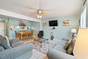 纳瓦拉Sugar Beach D17的一间带两张沙发的客厅和一间用餐室