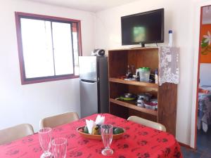 安加罗阿Cabañas y Hostal Vai Hinaaro的一间带桌子和电视的用餐室