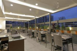 孟买Hotel Ariana Residency的屋顶餐厅设有桌椅