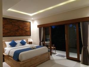 乌布Cahaya Guest House的一间卧室设有一张大床和一个大窗户
