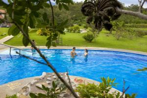 Hacienda GuayaboColinas del Miravalles Hotel & Hot Springs的一群人在游泳池里