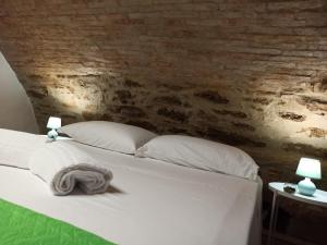PomaricoMatalena的一张带白色枕头和砖墙的床