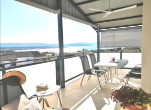 马林斯卡Lovely Sea View House in Malinska Island Krk的阳台配有桌椅,享有海景。