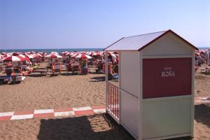 卡奥莱Giovanna Rooms的海滩上的一座建筑,上面有红白的遮阳伞