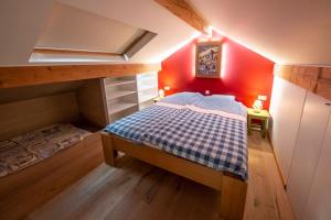 莱瓦尔坦Le Valtin Gite au calme的一间小卧室,配有床铺和红色的墙壁