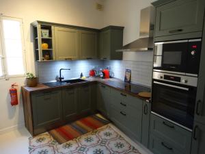 拉巴特60 Indri Borg Townhouse的厨房配有绿色橱柜和水槽