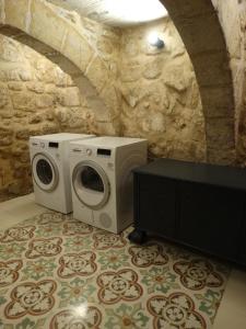 拉巴特60 Indri Borg Townhouse的石墙房间内的洗衣机和烘干机