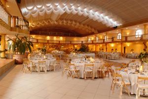 普拉亚德米拉金塔德拉格酒店的一个带白色桌椅的大型宴会厅