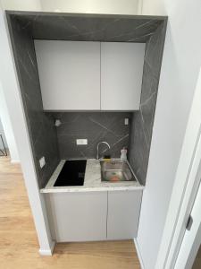 佩特罗瓦纳莫鲁Lungomare Apartments的厨房配有白色橱柜和水槽