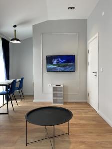佩特罗瓦纳莫鲁Lungomare Apartments的客厅配有桌子和墙上的电视